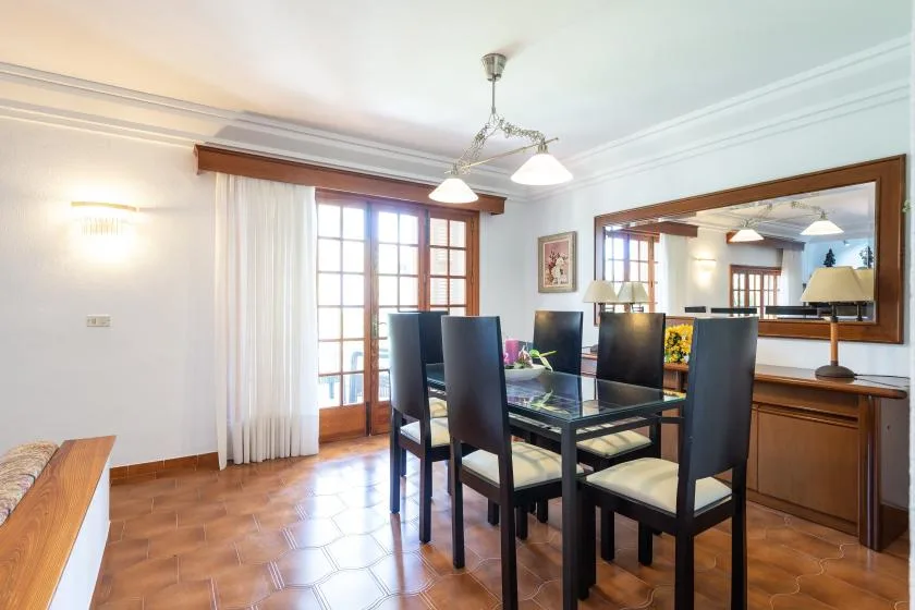 A dining room with a table and chairs beside glass doors.