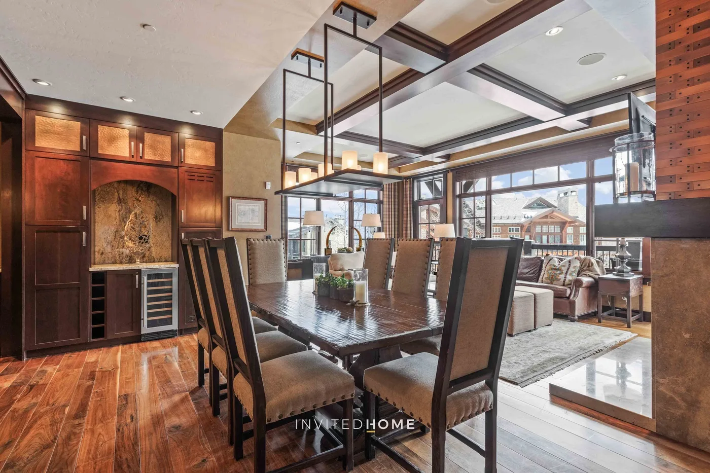 Dining area with a long table and large windows overlooking the living space.