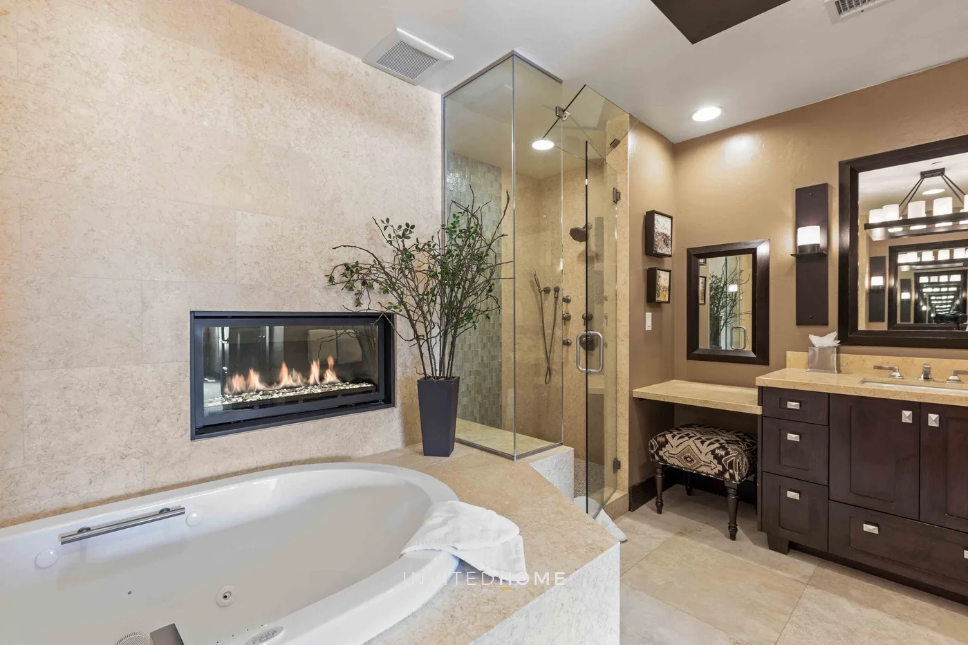A bathroom with a corner shower, soaking tub, and wall-mounted fireplace.