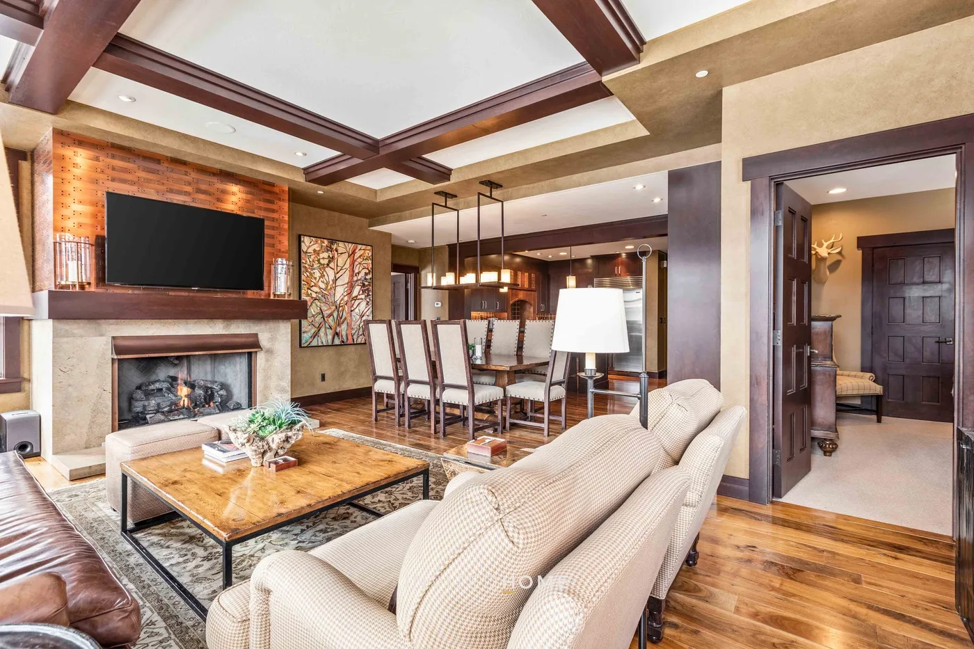 A living room with seating, a fireplace, and a dining area.