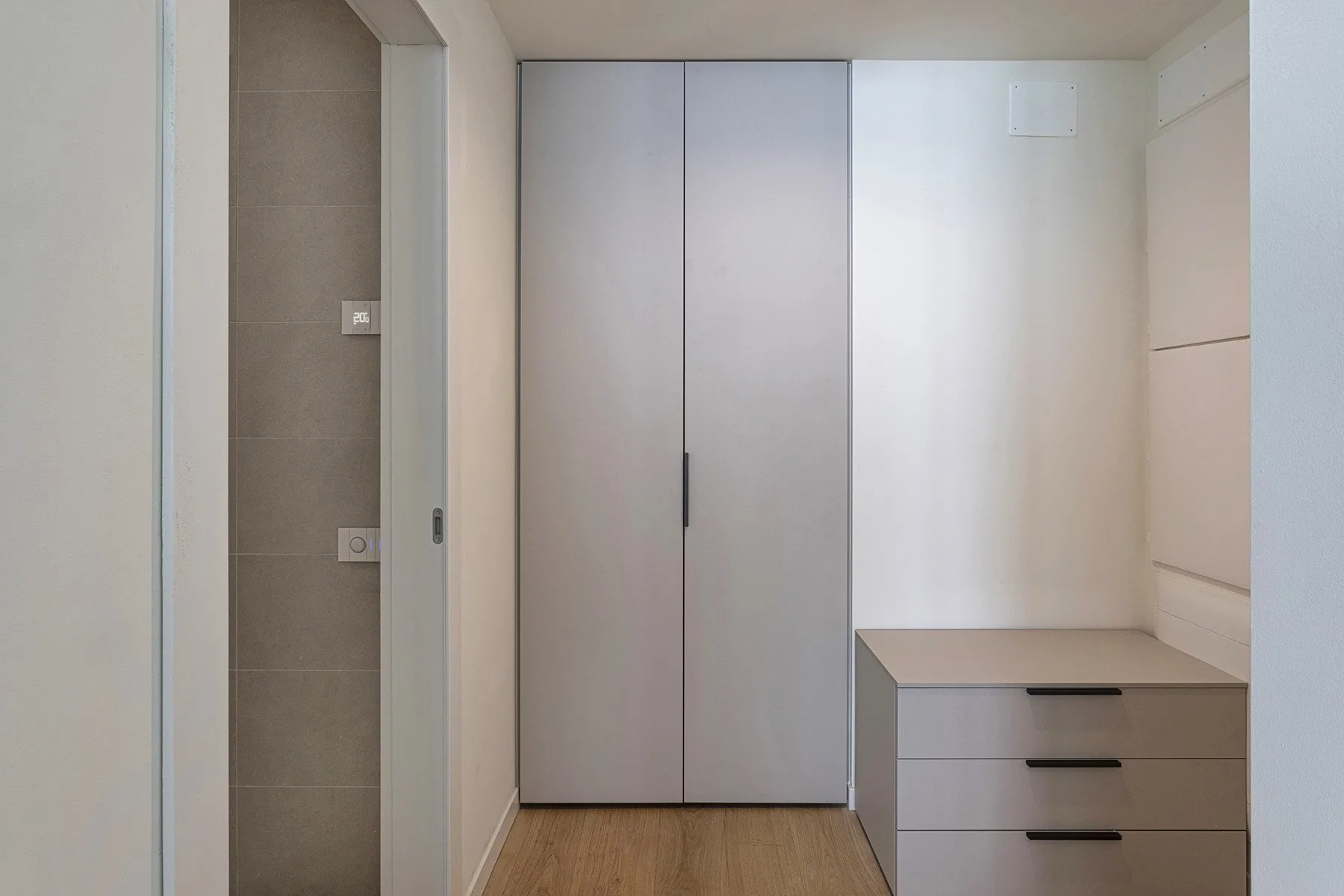 A compact room with a tall built-in cabinet and a low set of drawers.