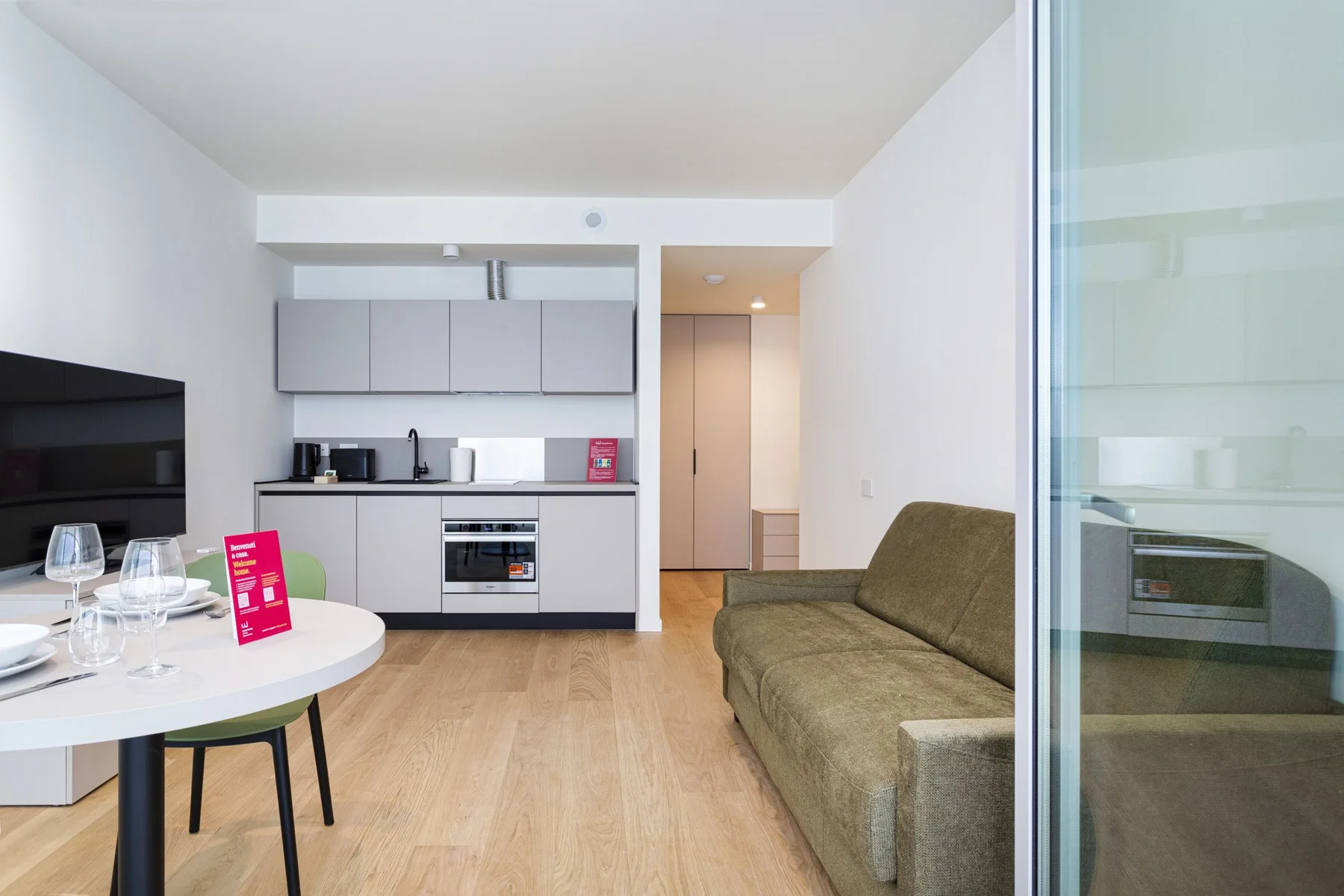 A bright living area with a kitchenette, dining table, and seating.