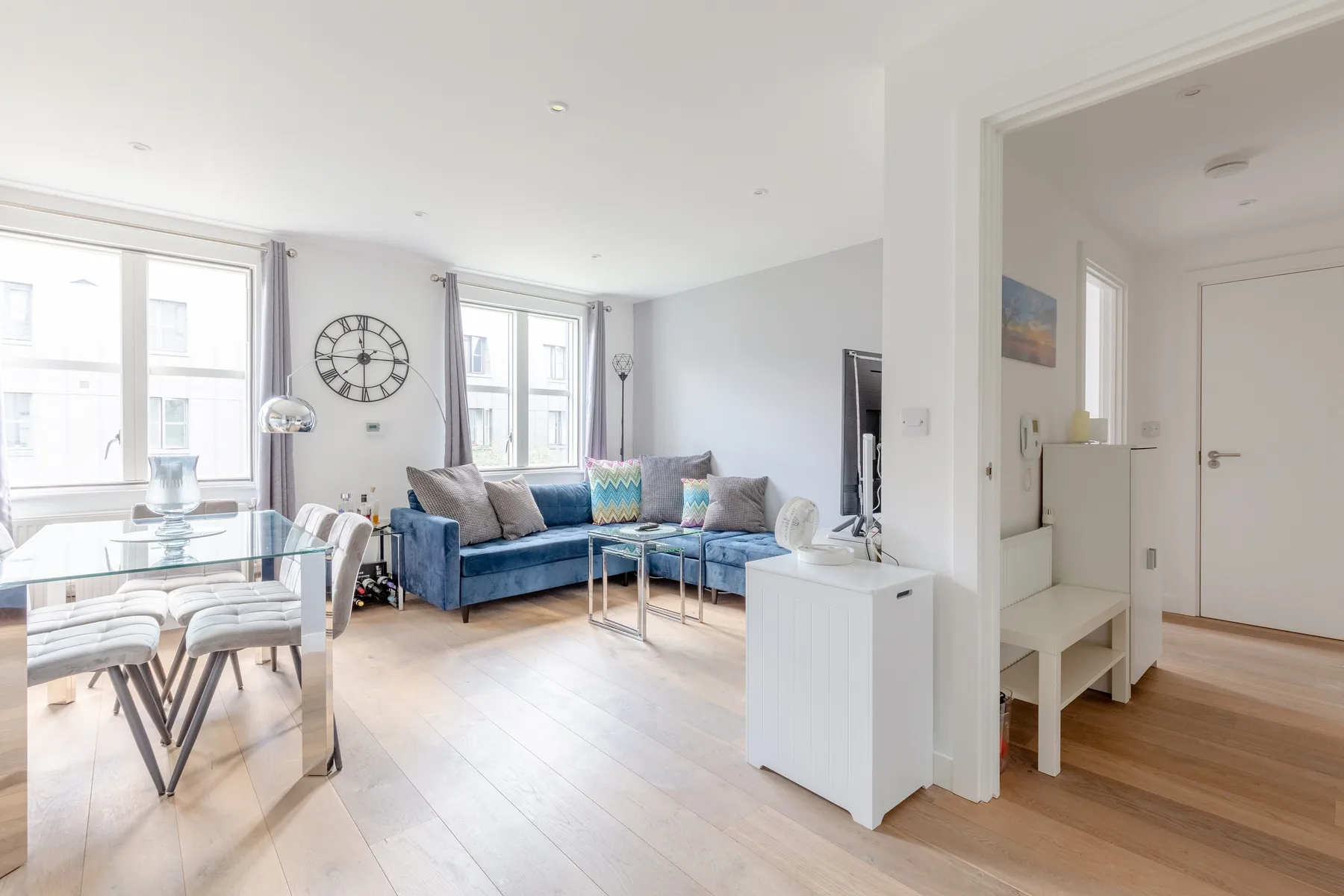 A bright living room with a dining area and blue seating.