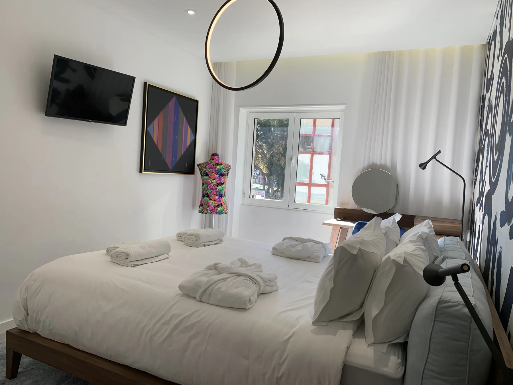 Un dormitorio luminoso con una cama bien tendida y una ventana.