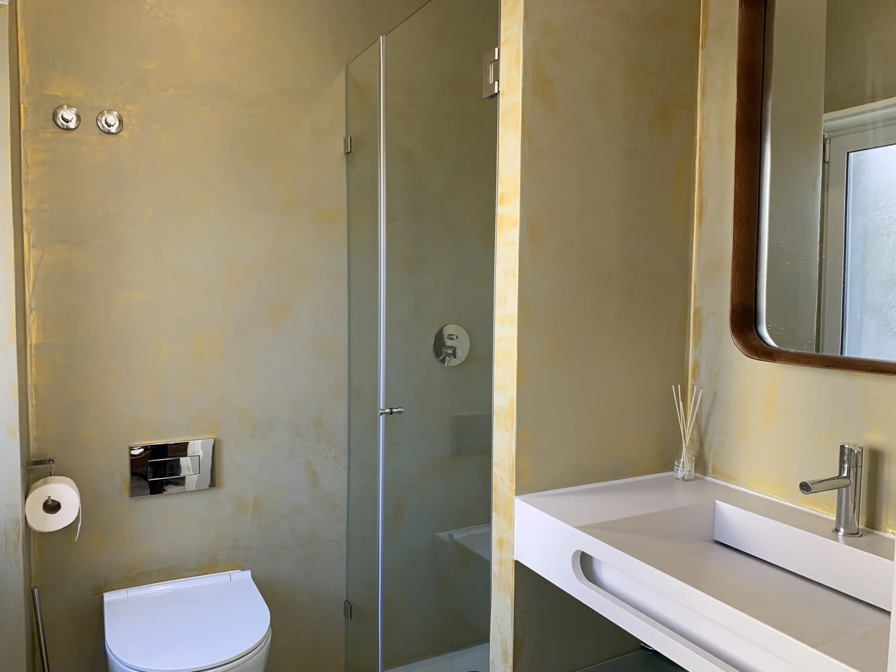 Un baño con inodoro, ducha de vidrio y lavabo.