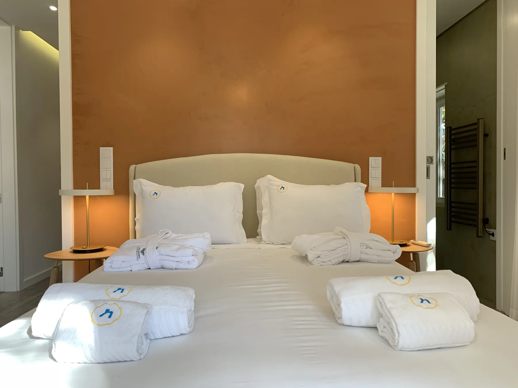 Un dormitorio con una cama, ropa de cama blanca y lámparas de mesilla.