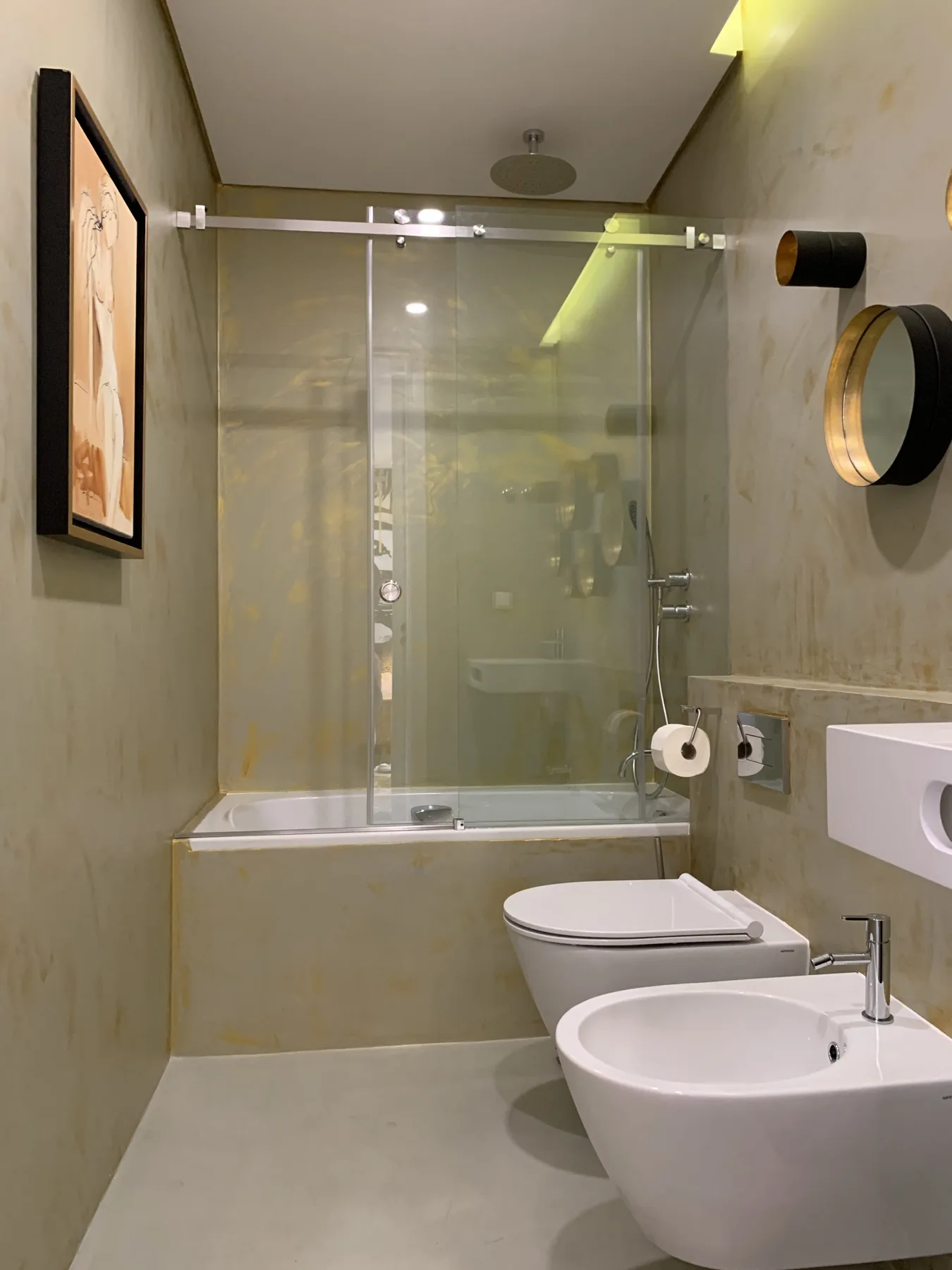 Un baño con ducha de vidrio, inodoro y lavabo.