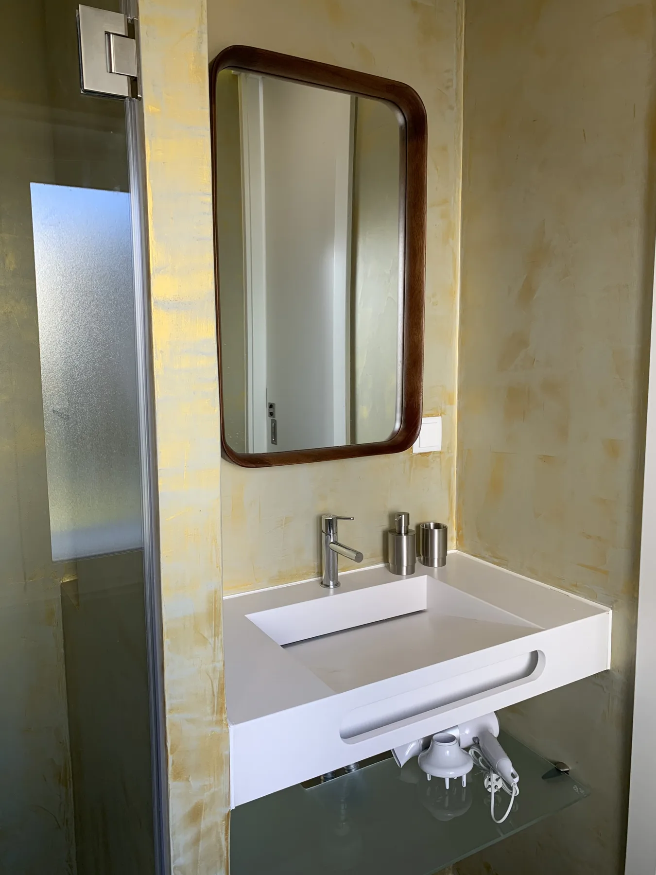 Un lavabo de baño con un lavamanos rectangular y un espejo en la pared.