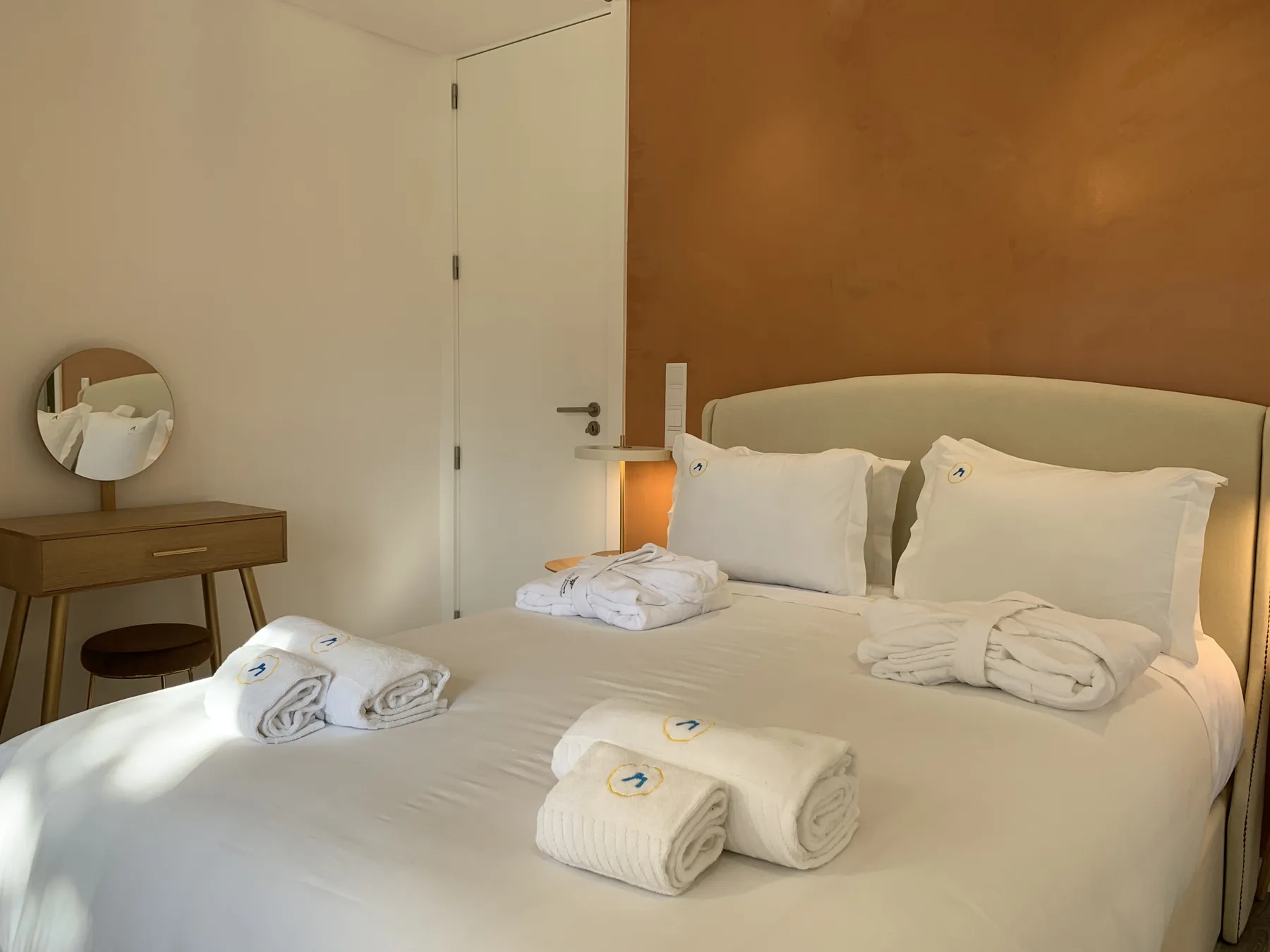 Un dormitorio con una cama bien hecha y toallas dobladas.
