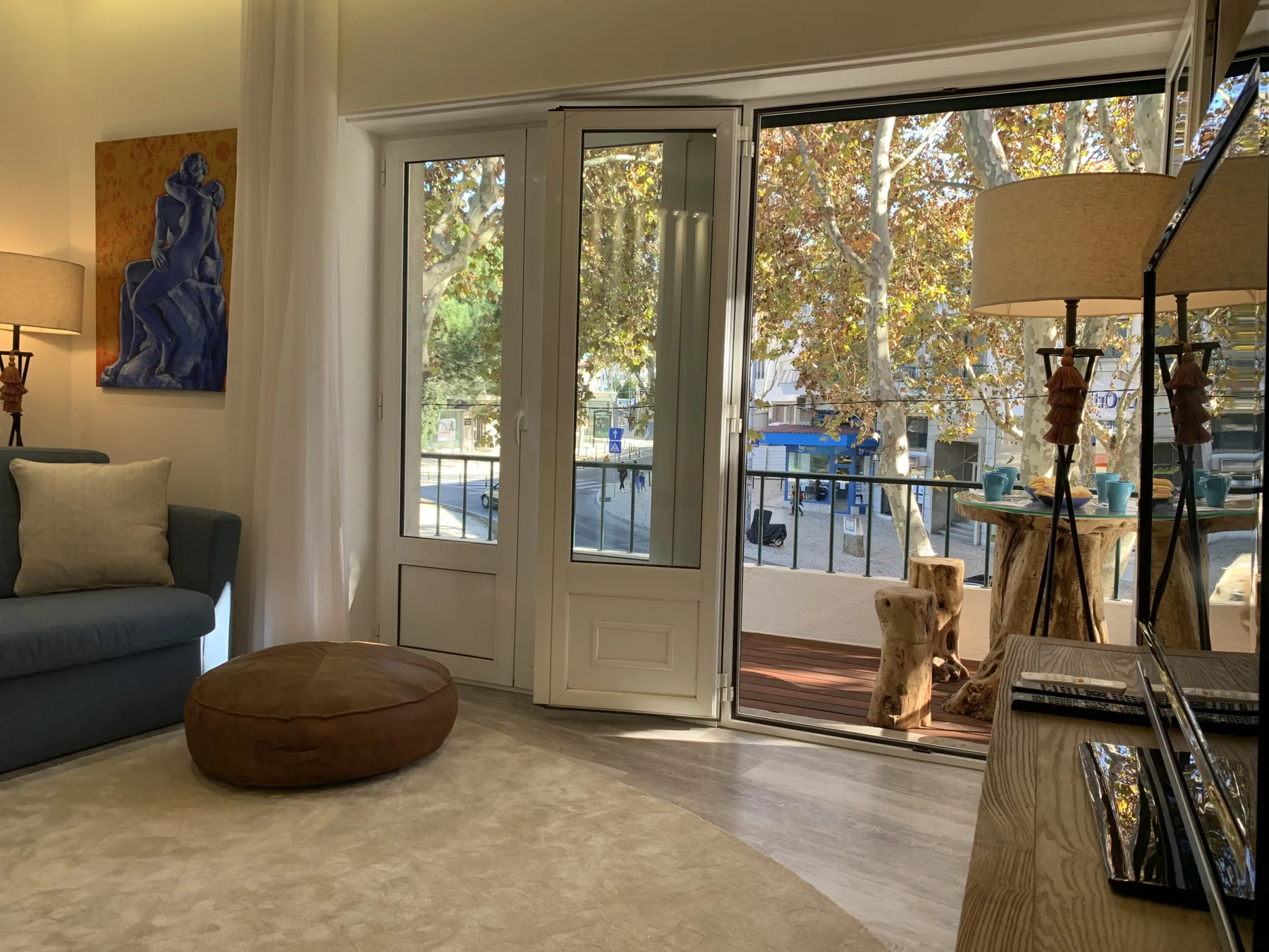 Una sala de estar con asientos y grandes puertas de vidrio que dan a un balcón.
