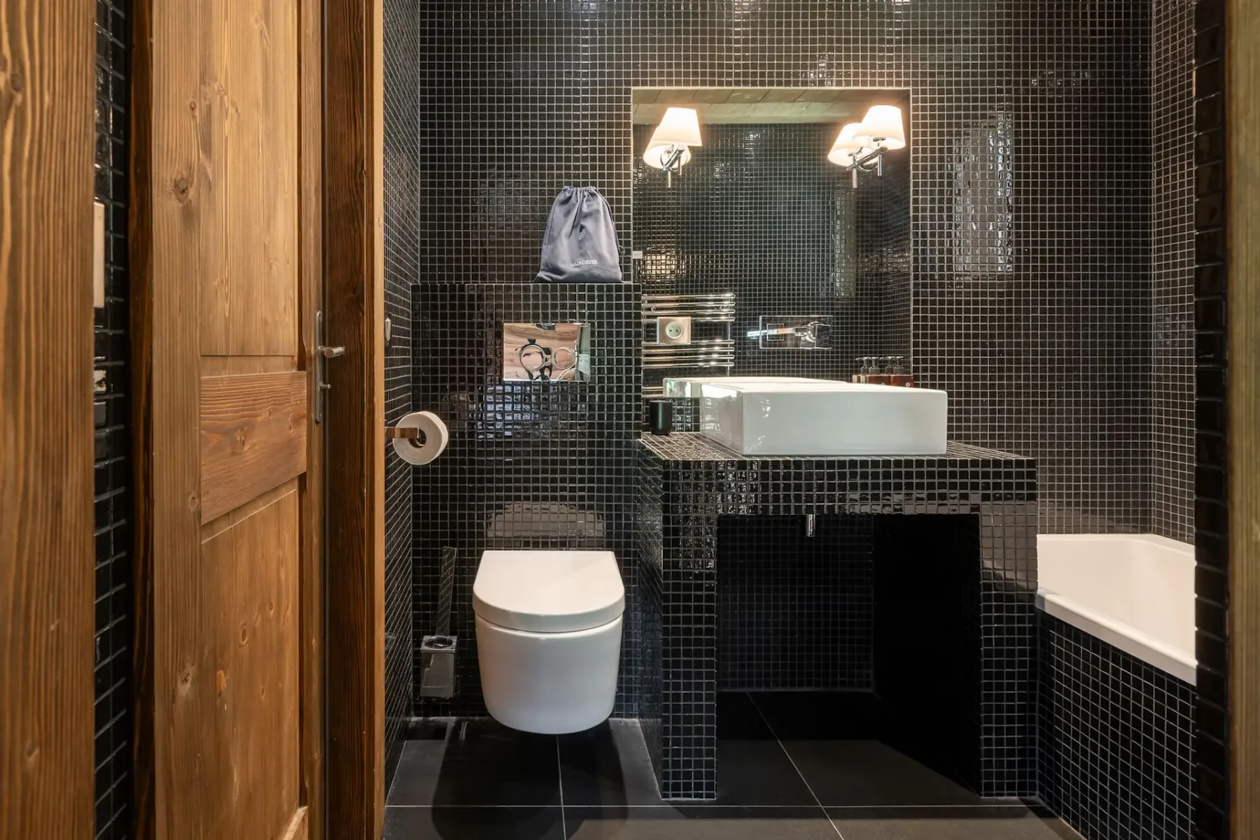 Un baño alicatado con lavabo, inodoro y bañera.