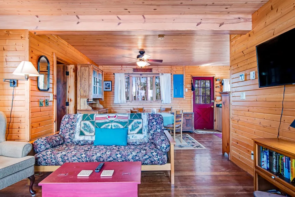 A wood-paneled living room with patterned seating and a television.