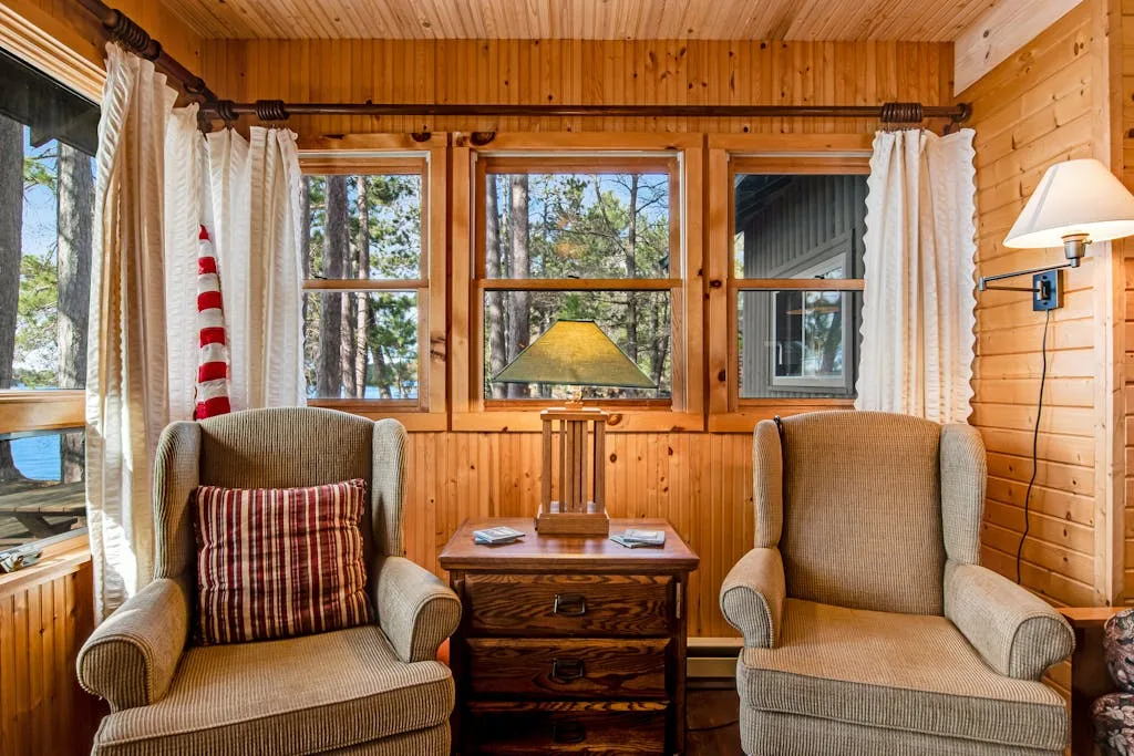 A wood-paneled sitting area with two armchairs arranged beside a small table.