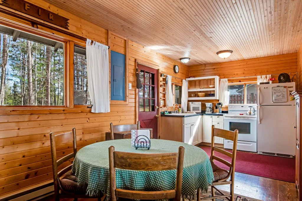 A wood-paneled kitchen and dining area with a round table beside the window.