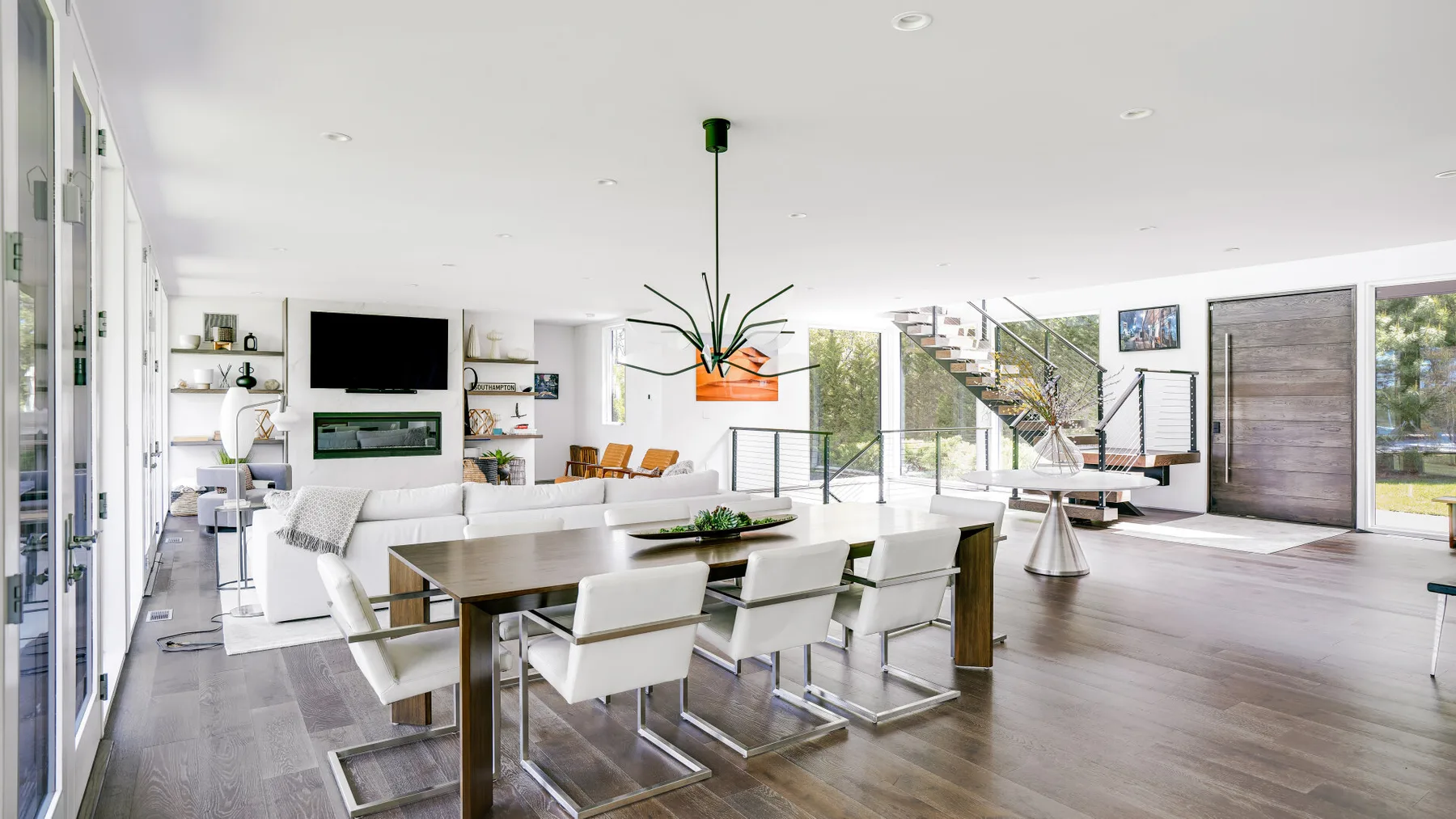 An open-plan living and dining area with a long dining table and seating.