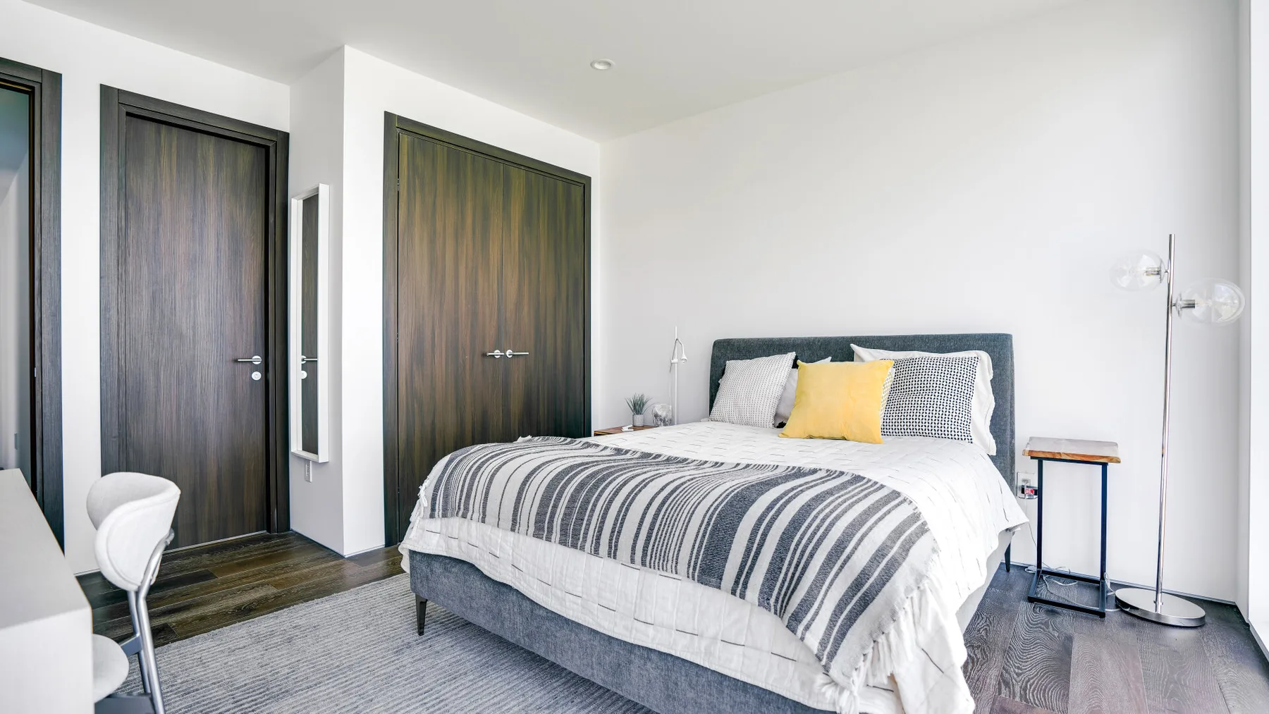 Bedroom with a bed dressed in striped bedding and a dark headboard.