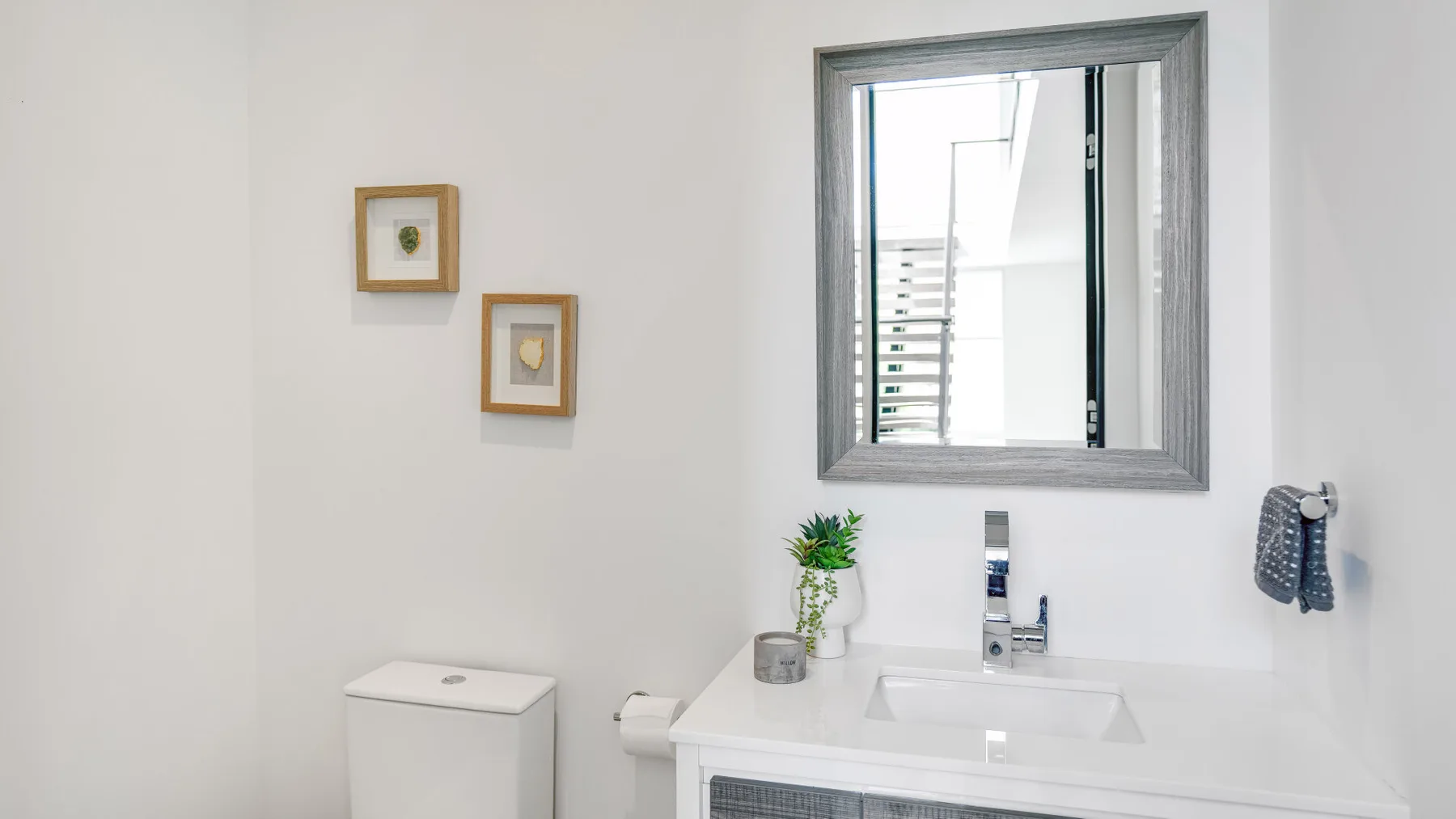 A bright bathroom with a sink, toilet, and large mirror.