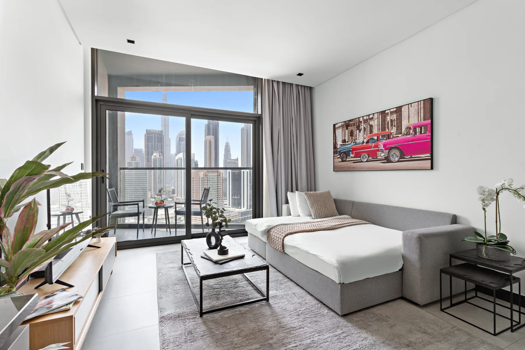 A bright living room with a large window overlooking city buildings.