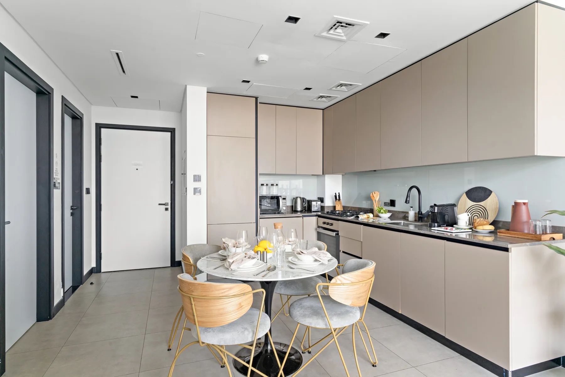 A modern kitchen and dining area with a table set beside the counter.