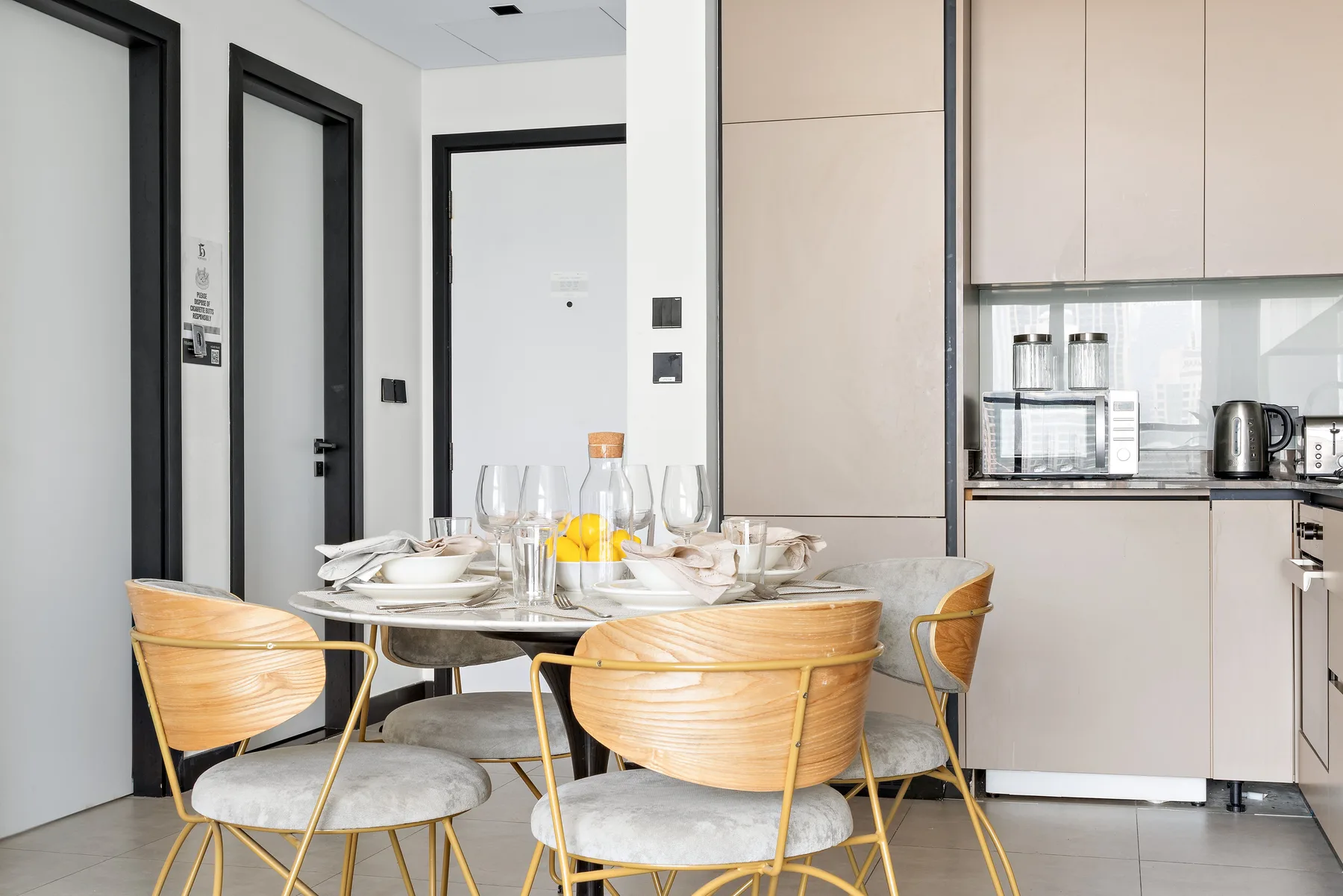 A dining area with a set table beside a compact kitchen.