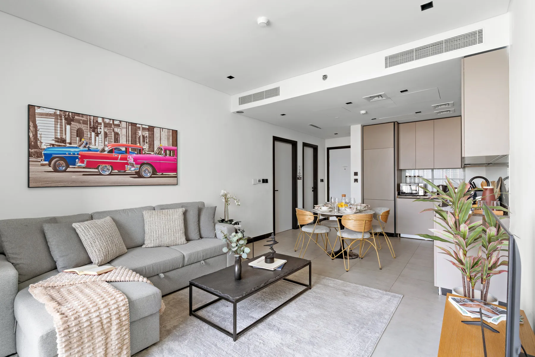 A modern living and dining area with gray seating and a table.