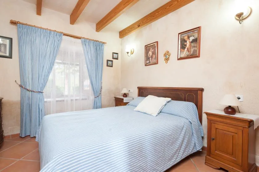 Un dormitorio con una cama vestida con ropa de cama a rayas azules y blancas.