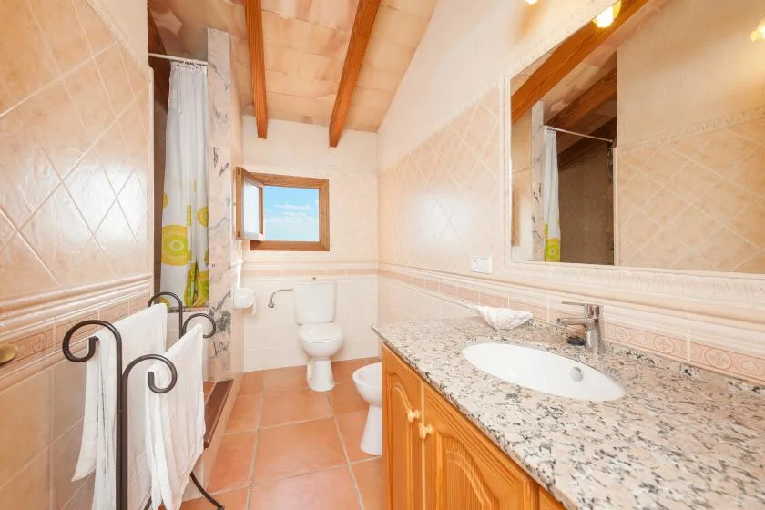 Un baño con lavabo, inodoro y ventana.