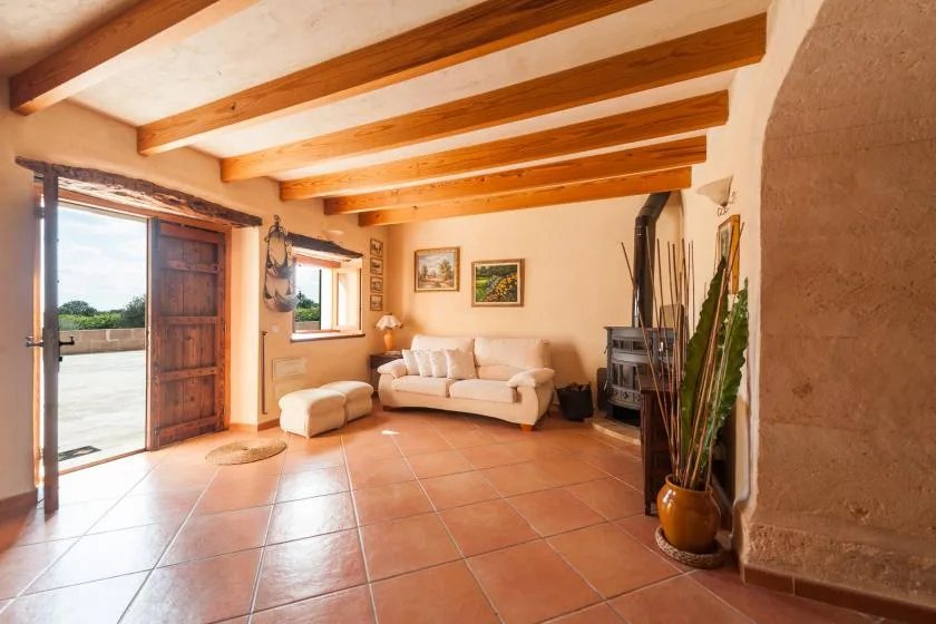 Una sala de estar con asientos, vigas de madera vistas y una chimenea.