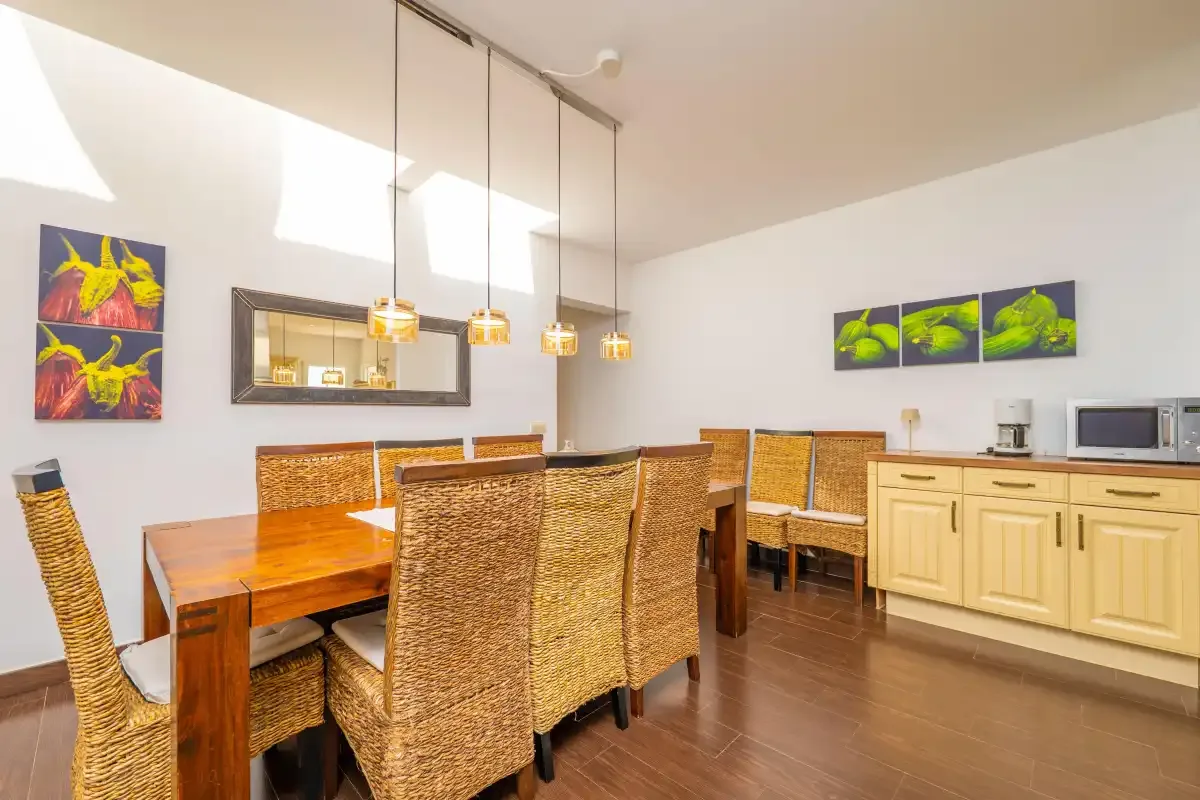 Un comedor con asientos de mimbre junto a una encimera de cocina.