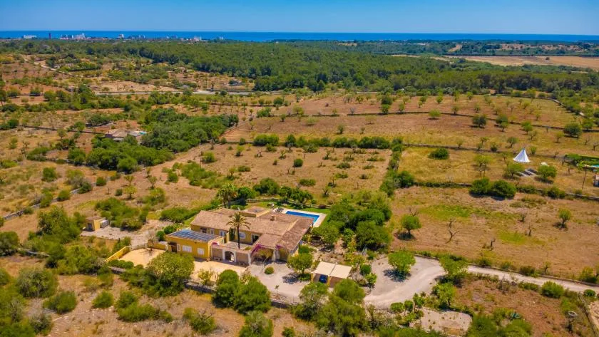 Vista aérea de una casa en medio de un paisaje rural seco y abierto.