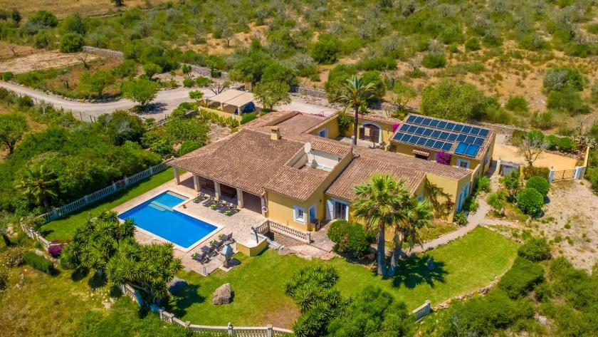 Vista aérea de una casa con piscina y jardines.