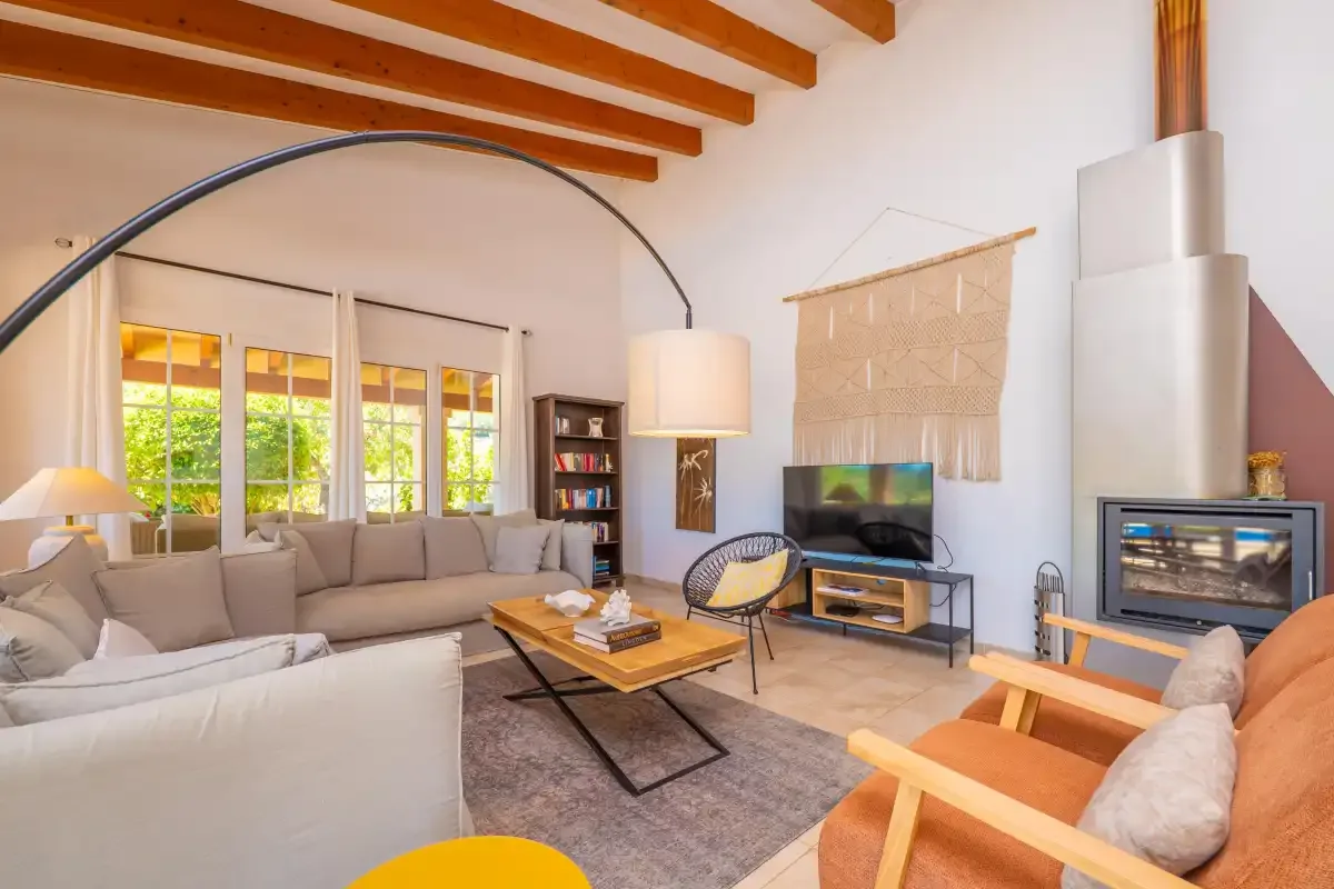 Una sala de estar luminosa con asientos, un televisor y una chimenea.
