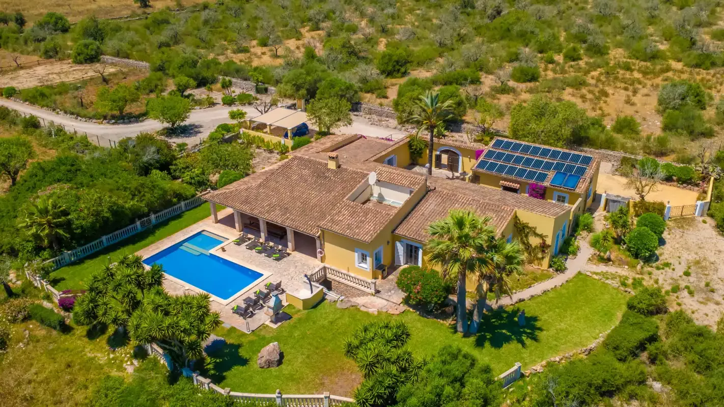Vista aérea de una casa con piscina y jardín ajardinado.