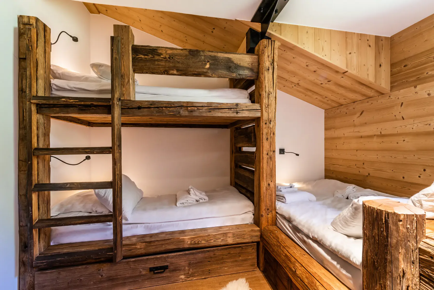 A sleeping area with wooden bunk beds and an adjacent single bed.