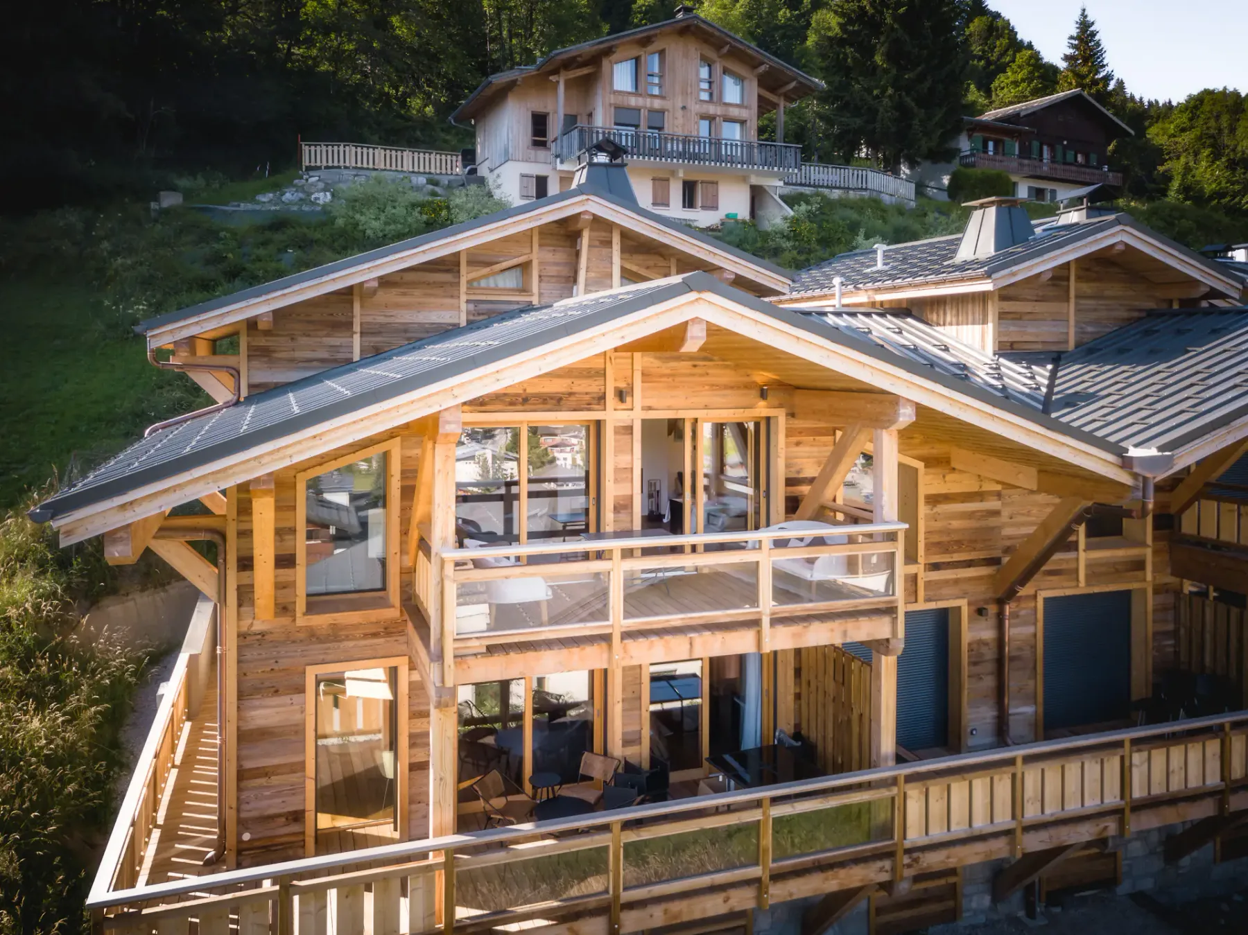 Exterior of a multi-level wooden building with balconies, surrounded by trees.