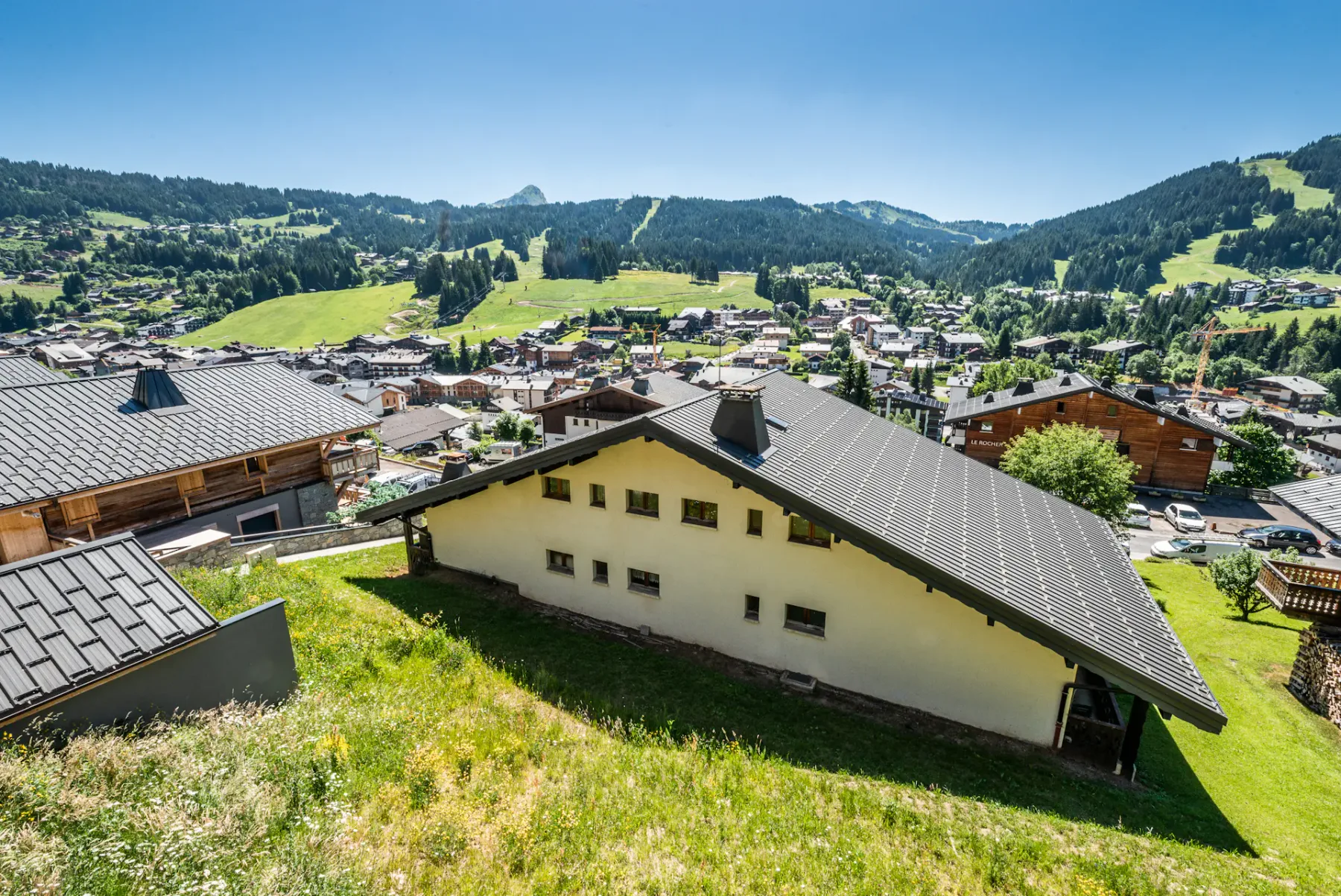 A hillside village with clustered buildings and green mountain slopes.