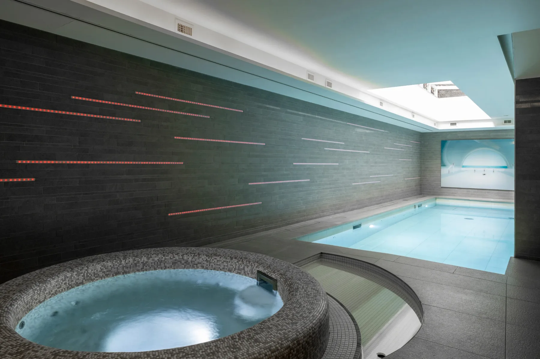 La zona Aqua Spa, con un jacuzzi delante y una piscina detrás.