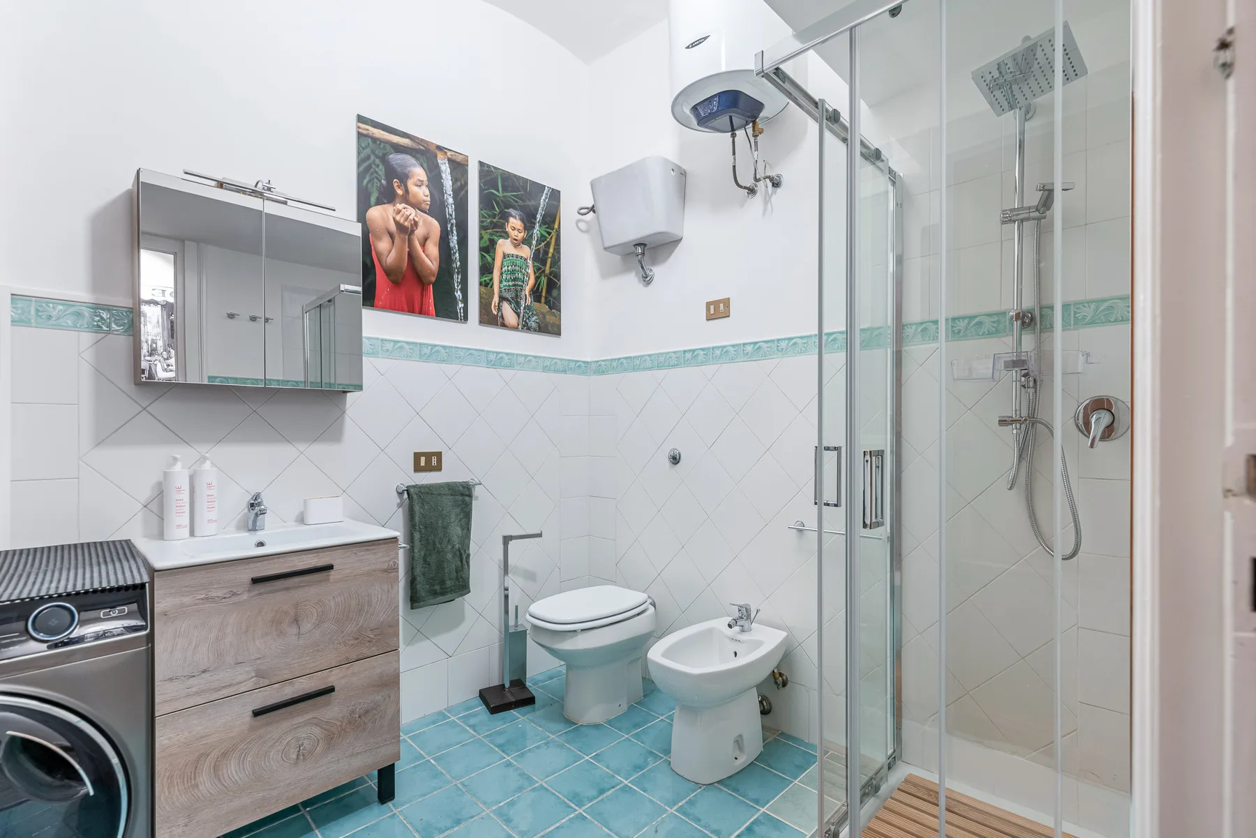 A tiled bathroom with a sink, toilet, bidet, and glass shower.
