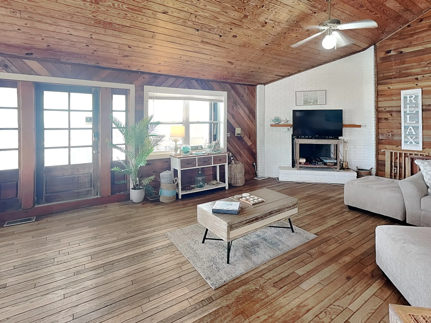 A living room with a television, seating, and a wooden coffee table.
