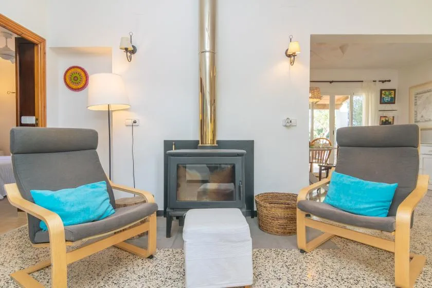 A living room with two armchairs facing a wood-burning stove.