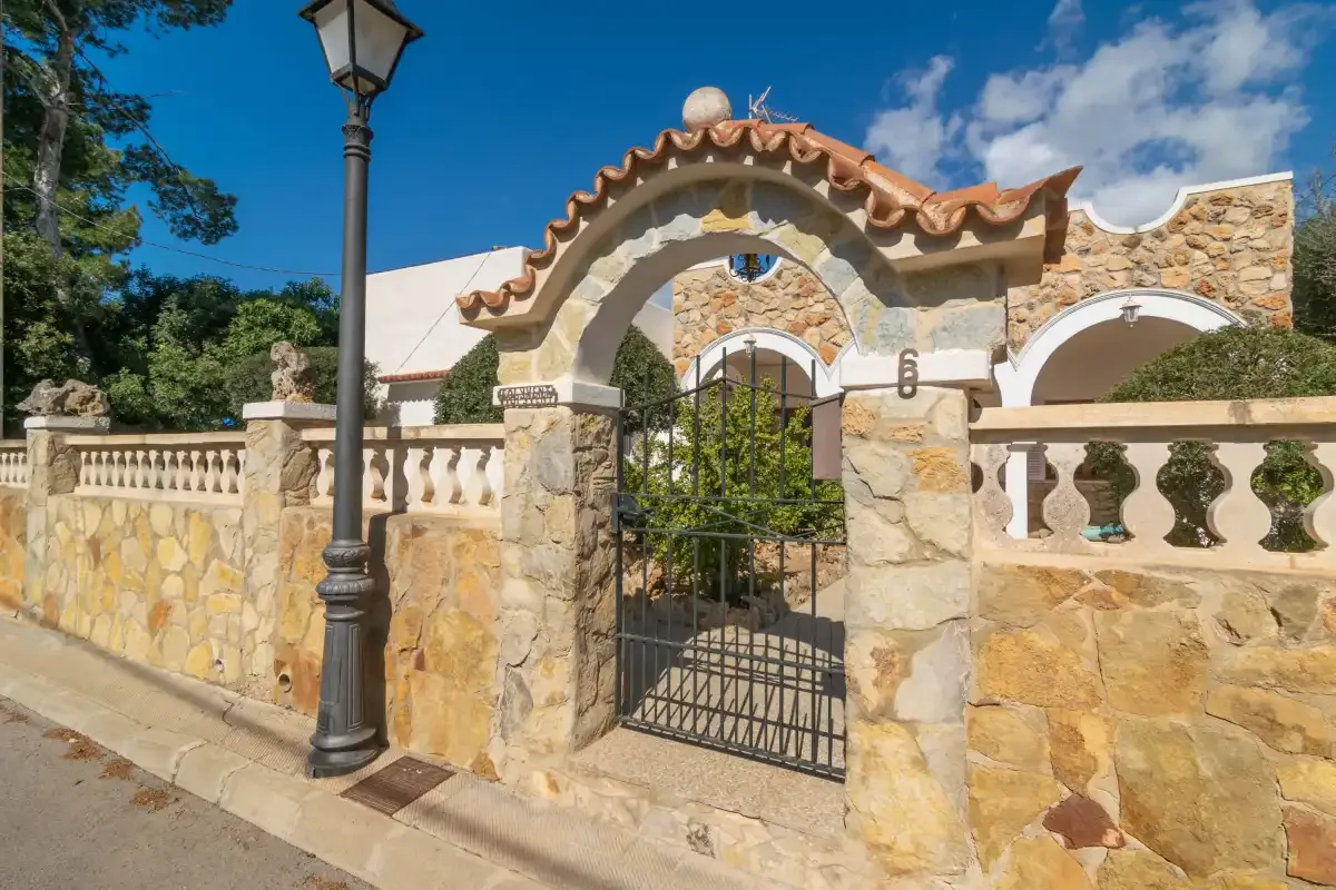 A stone entrance with a black metal gate and decorative arch.