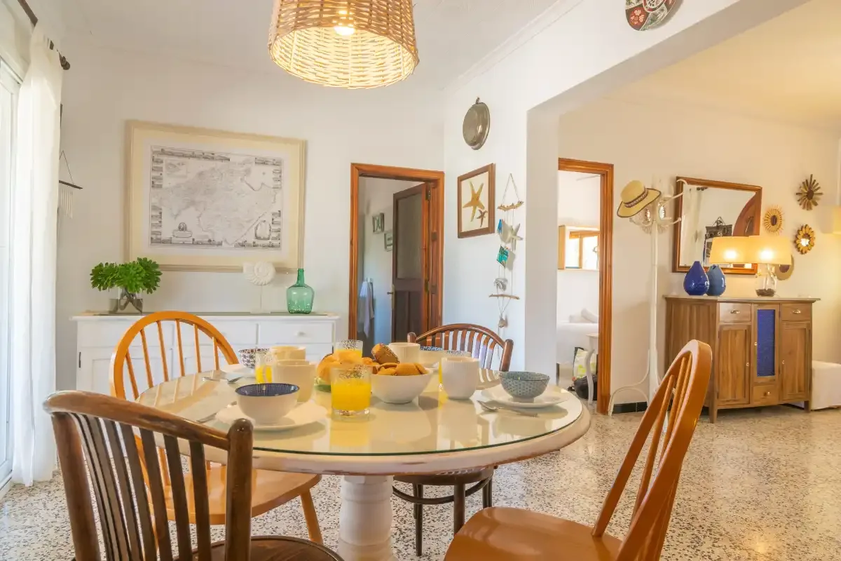A dining room with a round table and wooden seating.