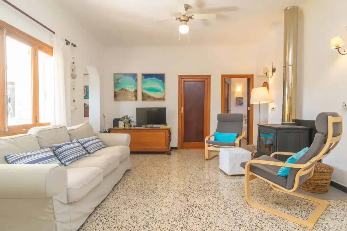 A living room with seating, a television, and a stove.