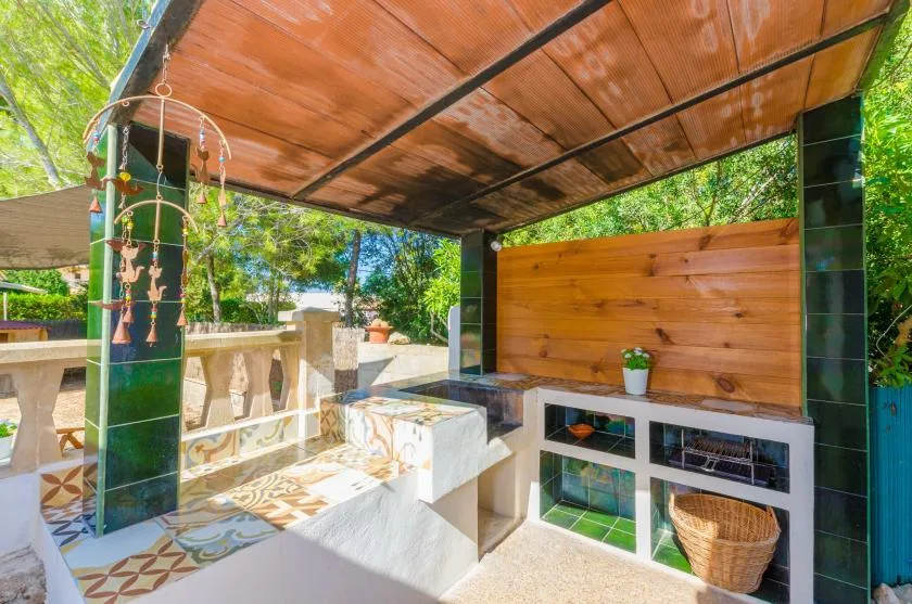 A covered outdoor patio with built-in seating and a wooden counter.