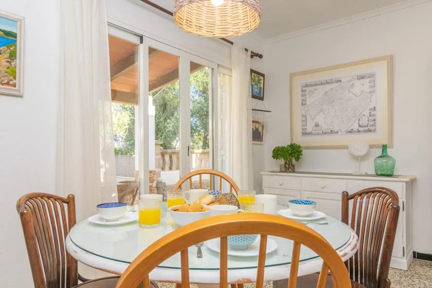A bright dining area with a round glass table and sliding glass doors.