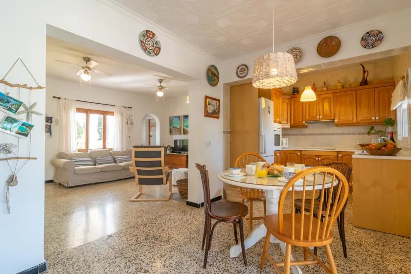 An open dining and kitchen area with a table set beside a living room.