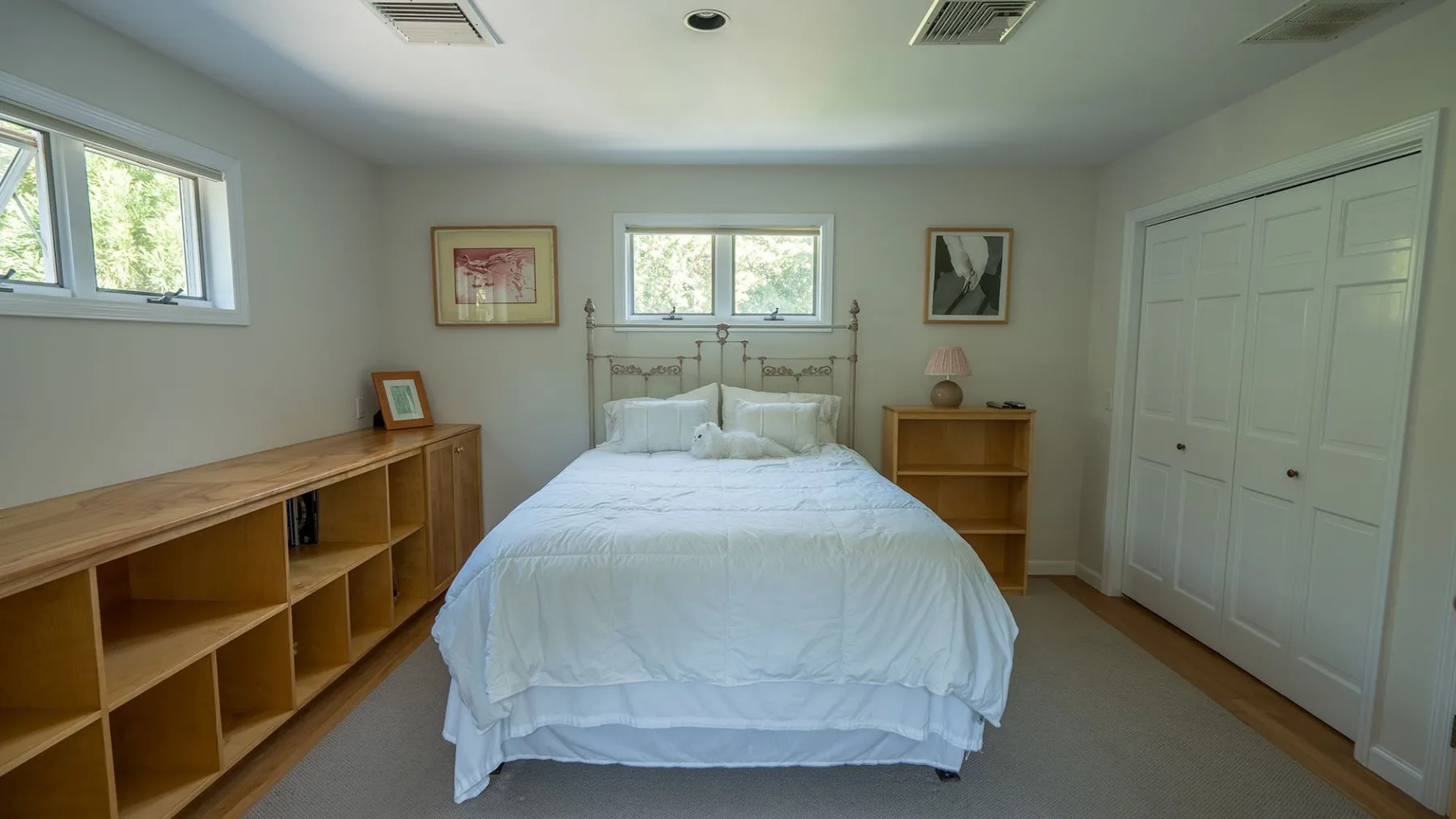 Un dormitorio con una cama, estanterías de madera y un armario.