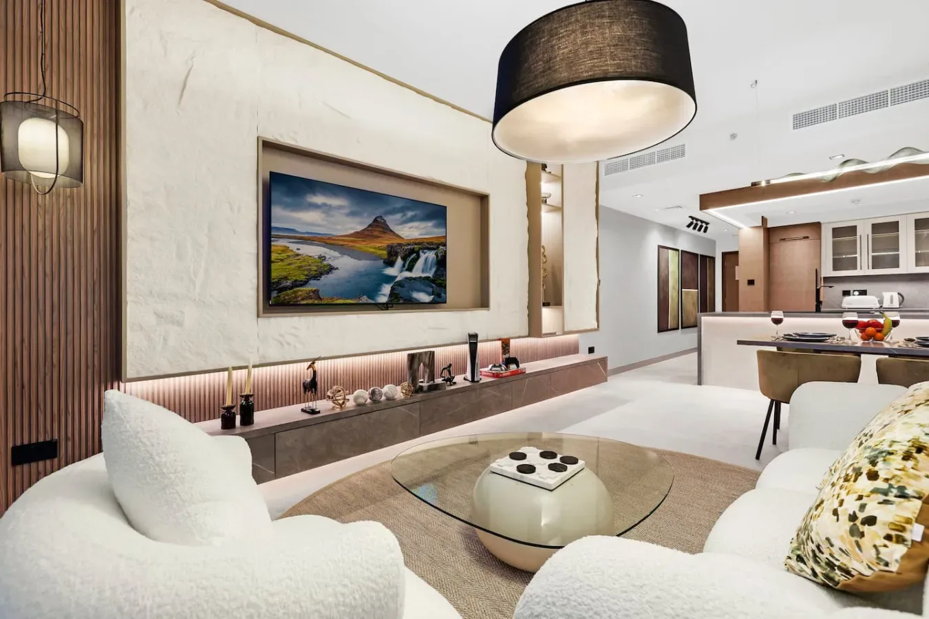 Una sala de estar moderna con asientos curvos y una mesa de centro de vidrio.