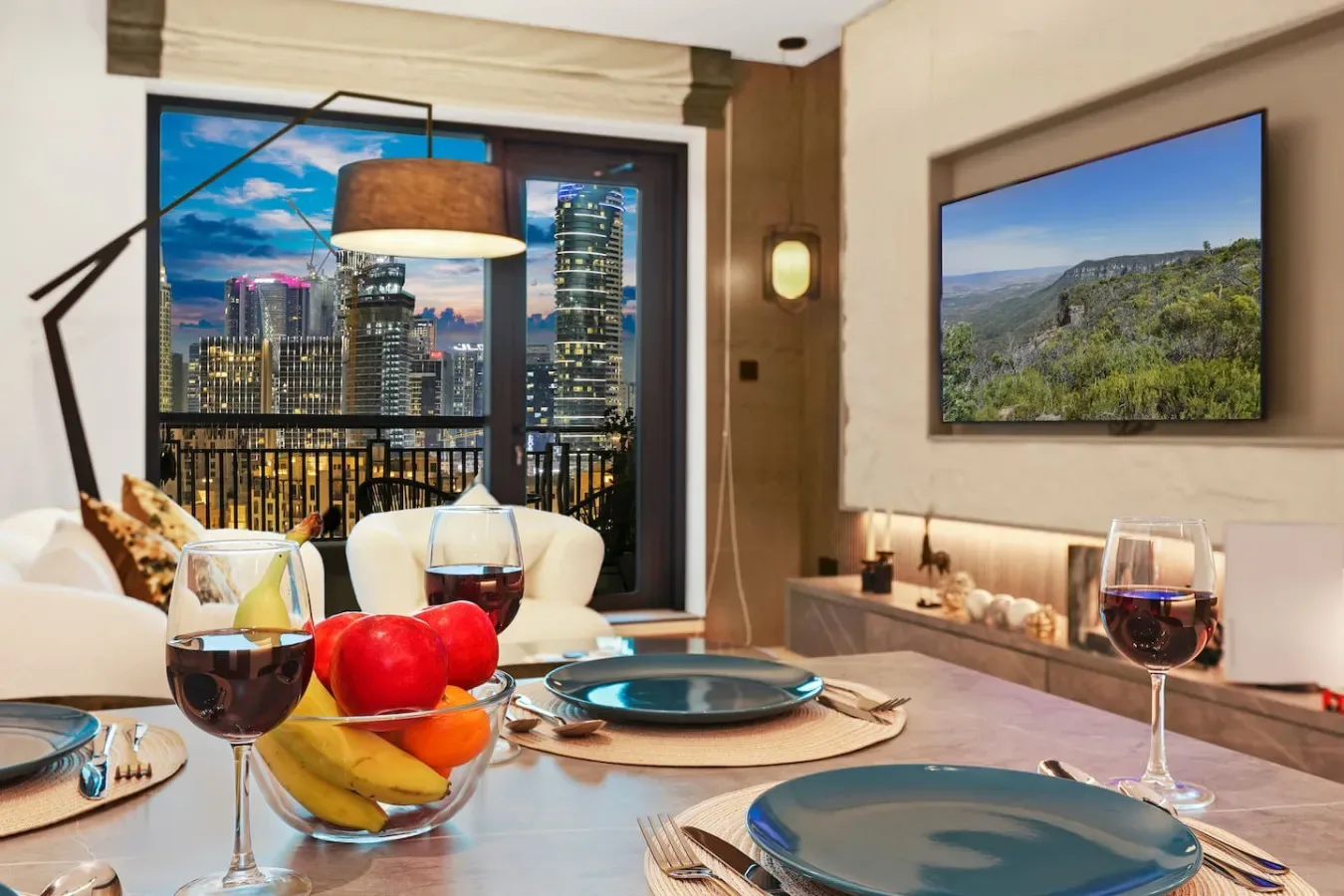 Un comedor con la mesa puesta y una gran ventana con vistas a la ciudad.