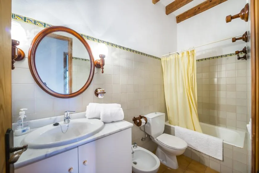 A bathroom with a sink, toilet, and bathtub behind a shower curtain.